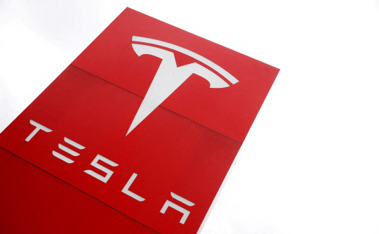 FILE PHOTO: The logo of car manufacturer Tesla is seen at a dealership in London, Britain, May 14, 2021. REUTERS/Matthew Childs/File Photo